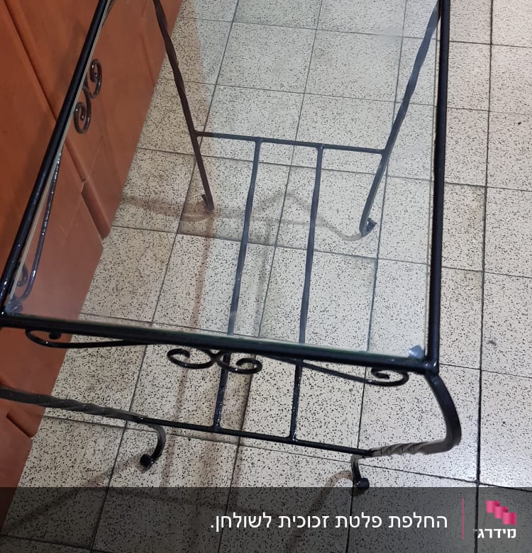 שולחן עם משטח זכוכית ומסגרת מתכת מעוצבת